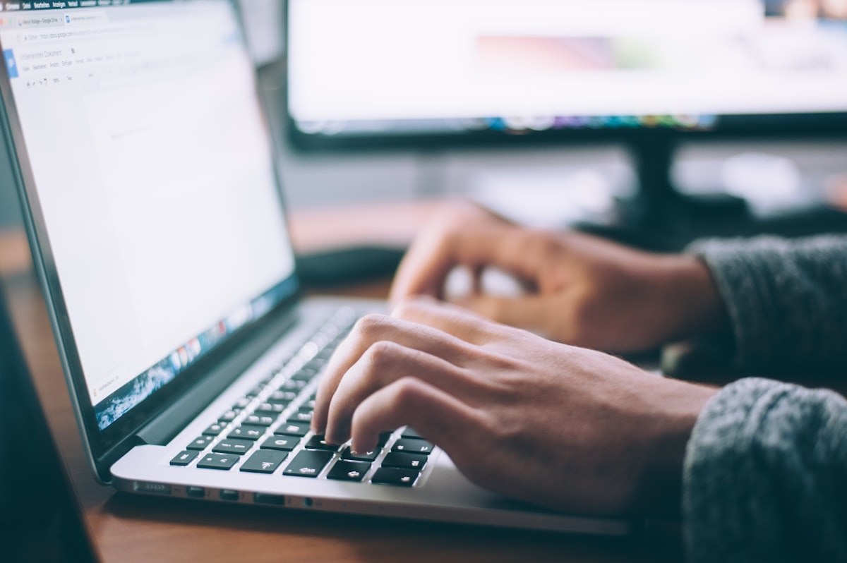 Writing on a laptop at a desk
